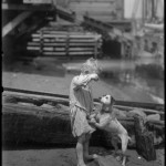 William Davis Hassler, barefoot son plays with dog on the shore of Harlem River,  ca. 1910, NYHS