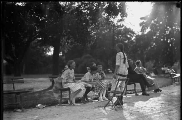 William Davis Hassler with four unidentified little girls in a park, talking and laughing, Isham Park, Inwood, New York City, undated ca. 1913-1914.